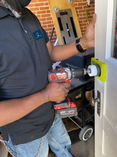Show a close-up of a locksmith's hands expertly working on a high-security lock. The hands are clean and gloved, and the tools are well-maintained. The background is blurred, focusing on the precision and professionalism of the work. The lighting should be bright and even.