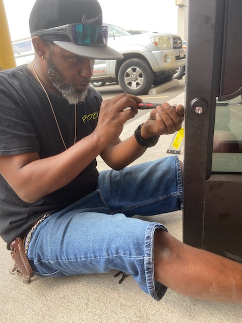 Close-up of a locksmith rekeying a lock cylinder, showcasing the intricate mechanism and precision involved. The background is clean and focused, highlighting the technical aspect of the service. Tools are modern and well-maintained.